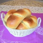 Panini all’olio dorati in cestino bianco su tovaglia viola