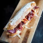 Panino con salami e formaggio fuso in baguette calda